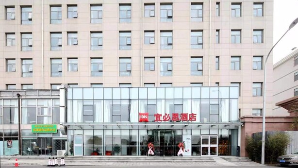 A hotel with a modern facade, large windows, and a prominent entrance. - Ibis Hotel (Beijing)
