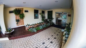 A hotel lobby with a tiled floor, a reception desk, and a seating area with plants and a small fountain. - Route Hotel Uberaba (Uberaba)