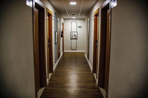 A hotel corridor with wooden flooring, doors on both sides, and a framed picture on the wall. - Route Hotel Uberaba (Uberaba)
