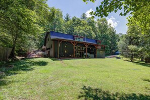 A rustic cabin with a porch, surrounded by a lush green landscape. - Seven Feathers A Modern Barn Retreat/ Pet & Family Friendly (Blue Ridge)