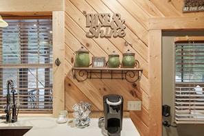 A kitchen with wooden walls, a coffee machine, and a shelf with green coffee pots. - Seven Feathers A Modern Barn Retreat/ Pet & Family Friendly (Blue Ridge)