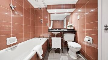 A modern bathroom with a bathtub, toilet, and sink.