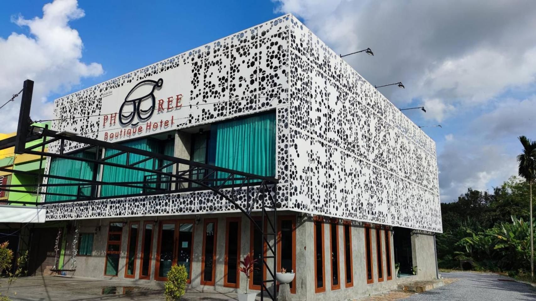 A building with a distinctive exterior featuring a pattern of black dots on a white background, labeled 'PHREE Boutique Hotel.'
