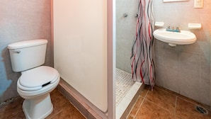 A bathroom with a toilet, a shower, and a sink. - OYO Hotel Estacion (La Antigua)