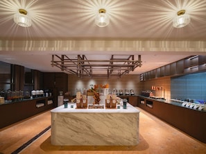 A modern hotel lobby with a marble reception desk, a central light fixture, and a large window. - Vienna International Hotel Kunming (Kunming)