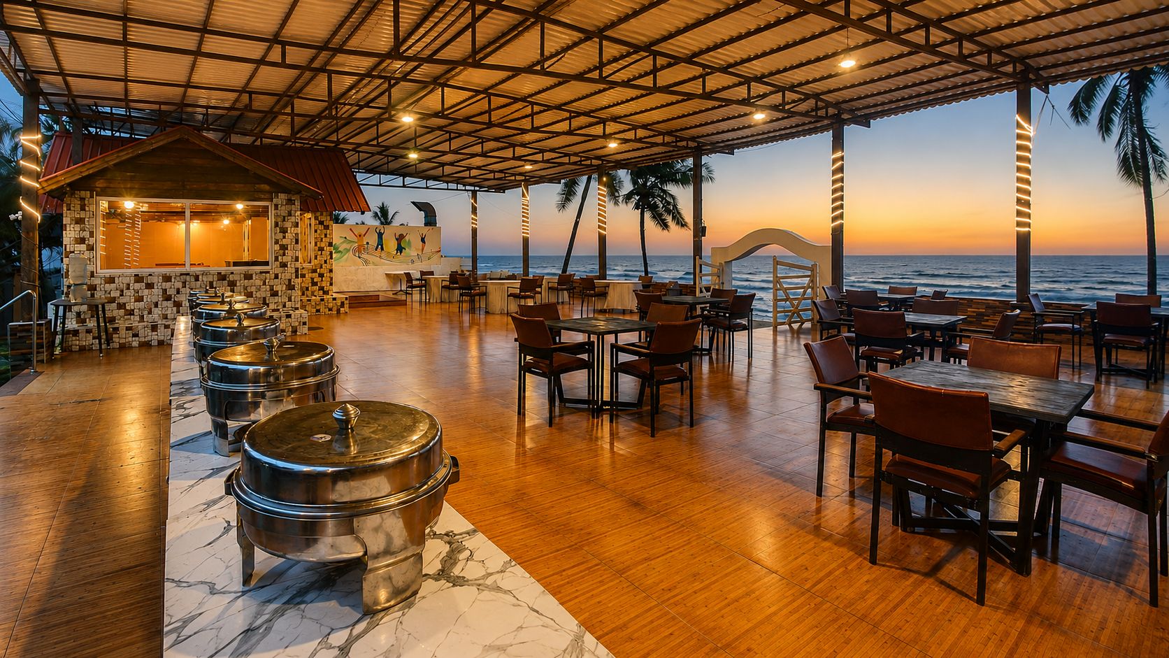 Un restaurante con terraza frente al mar, que presenta suelo de madera, ollas de metal para servir y una pared de piedra con un mural.