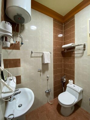 Ein Badezimmer mit Waschbecken, Toilette, Handtuchhalter und Föhn.