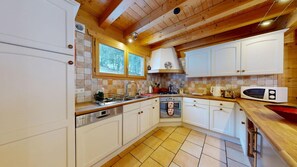 A kitchen with white cabinets, a built-in oven, and a microwave.