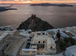 Un hôtel situé sur la côte, doté d’une piscine, d’un espace extérieur aménagé et offrant une vue sur la mer et les îles.