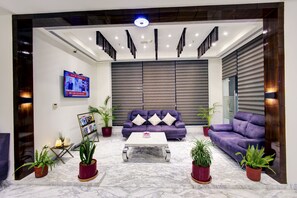 Una sala de estar moderna con un conjunto de sofá, una mesa de centro y plantas en macetas.