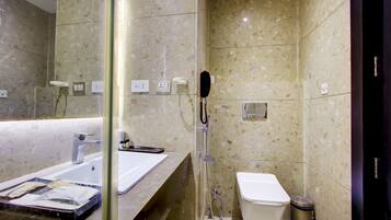 A modern bathroom with a glass partition, a shower area, a toilet, and a sink with a mirror.