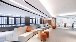 A modern lobby with a curved seating area, large windows, and a clean, minimalist design. - Even Hotel Chongli (Zhangjiakou)