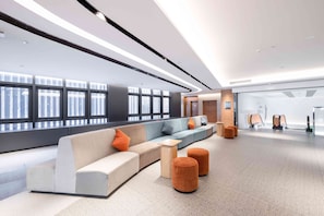 Un hall d’entrée moderne doté d’un espace salon aux lignes courbes, de grandes fenêtres et d’un design épuré et minimaliste.
