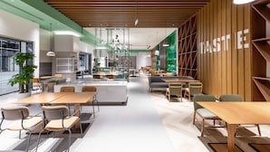 A modern interior with a central seating area, wooden accents, and a green accent wall with the word 'TASTE'. - Even Hotel Chongli (Zhangjiakou)
