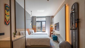 A modern hotel room with a large bed, a workout ball, and a wall-mounted exercise machine. - Even Hotel Chongli (Zhangjiakou)