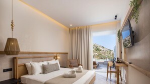 A hotel room with a bed, a desk, a chair, a television, and a view of the outdoors. - Ladiko Suites (Rhodes)