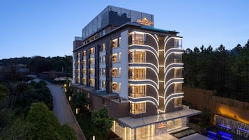 A multi-story hotel with a modern design, featuring a prominent sign on the roof and a well-lit facade.