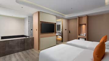 A modern hotel room with a flat-screen TV, a bathtub, and two beds with pillows.