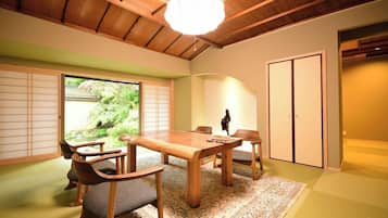 A traditional Japanese room with tatami flooring, a wooden dining table, and sliding doors.