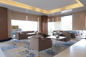 A modern hotel lobby with a seating area, large windows, and a view of the outside. - Palm Boutique Hotel Al Salamah (Jeddah)