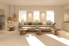 A modern living room with a large sofa, wooden coffee tables, and pendant lighting. - Mazee New Age Hotel (Paros)