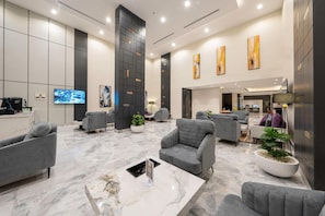 A modern lobby with grey sofas, a marble coffee table, and artwork on the walls. - Gardn Millennium Al-salamah Hotel Jeddah (Jeddah)