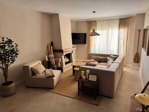 A modern living room with a sofa set, a coffee table, a fireplace, and a television mounted on the wall. - Beachfront • Sea Views • The Mimosas • La Cala de Mijas (La Cala de Mijas)