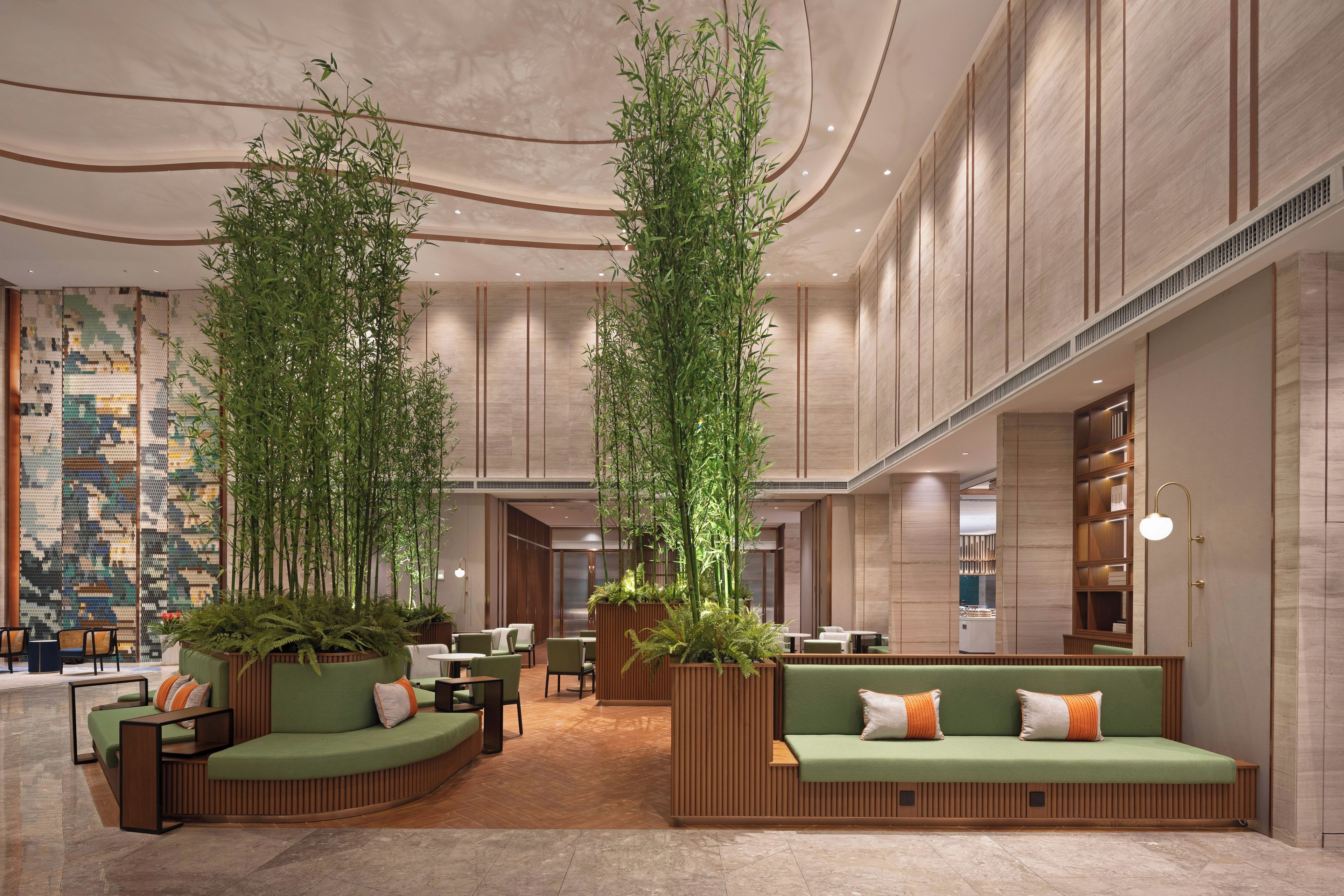 A spacious lobby with high ceilings, modern furniture, and vertical gardens.