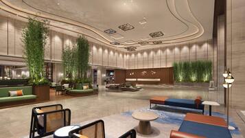 A spacious lobby with seating areas, a reception desk, and decorative lighting.
