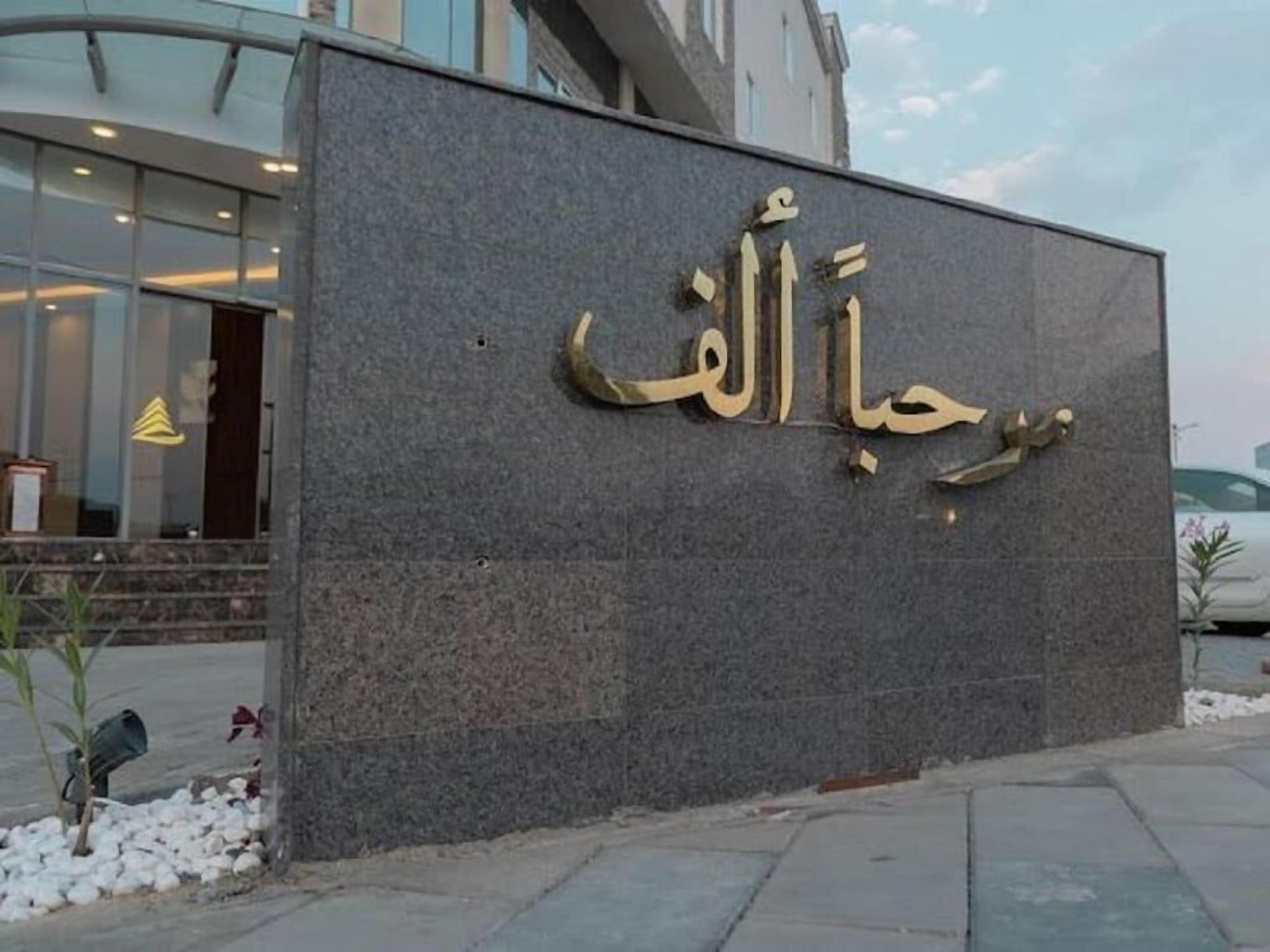 A building facade with a large sign in Arabic script.