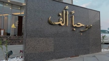 A building facade with a large sign in Arabic script.