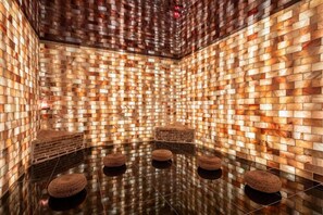 A room with a brick-patterned wall, a reflective floor, and four woven stools. - Wyndham Qingyuan Lianzhou Hot Spring Resort (Qingyuan)