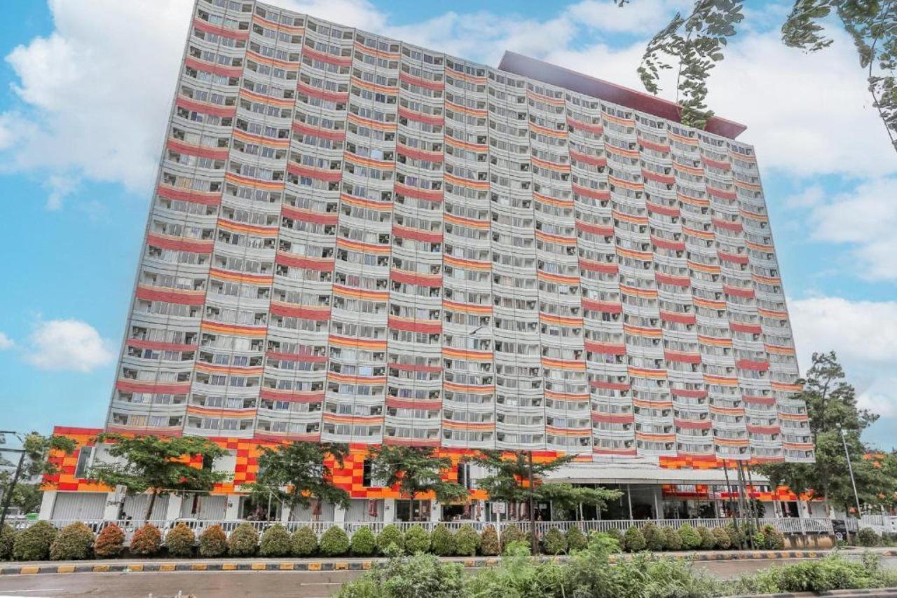 A multi-story hotel with a uniform facade, balconies, and a flat roof.