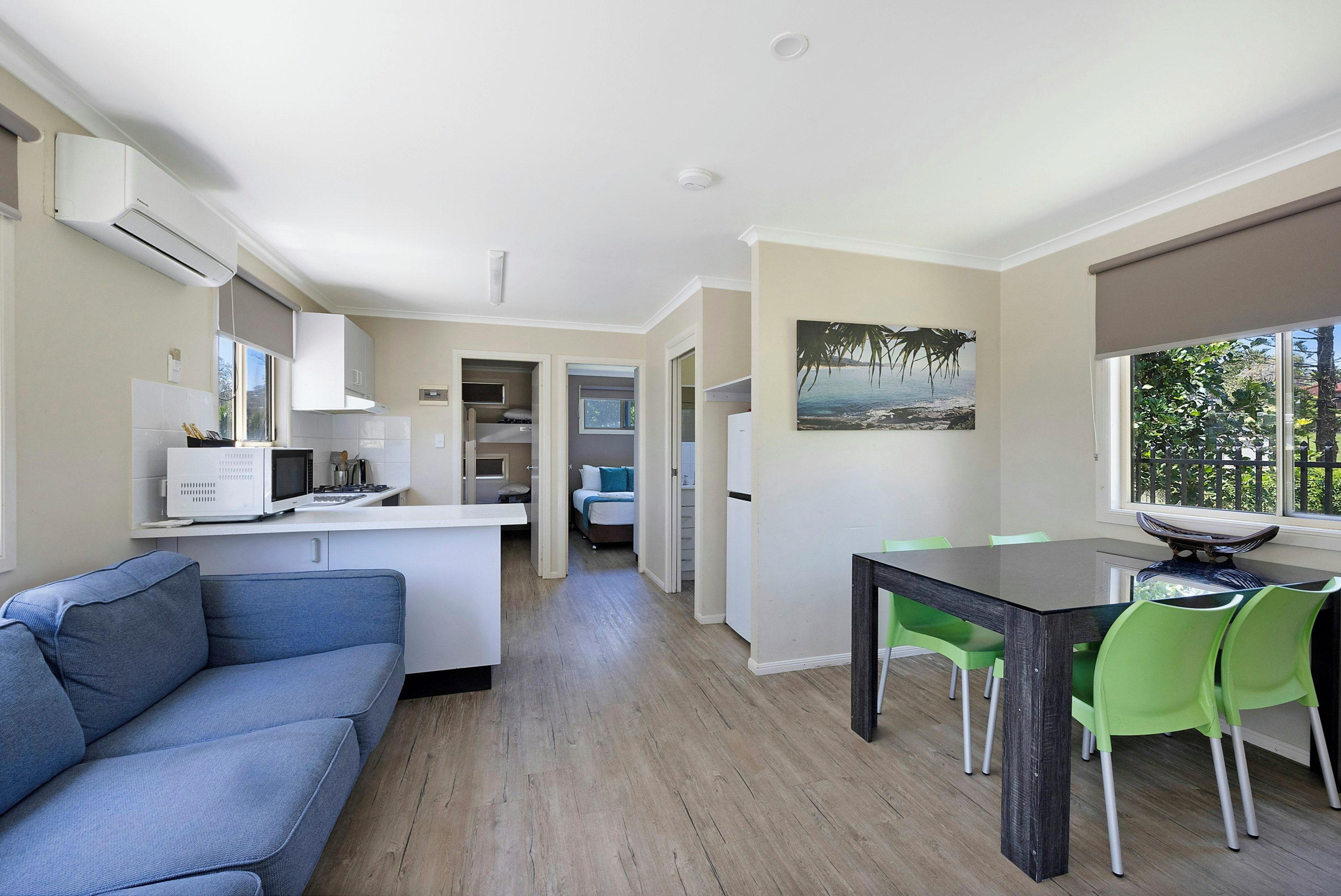 A compact living space with a kitchenette, a dining area, and a sofa.
