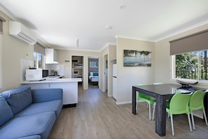 A compact living space with a kitchenette, a dining area, and a sofa. - Reflections Holiday Parks Scotts Head (Scotts Head)