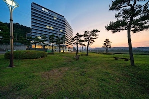Ein Hotel mit modernem Design, einem begrünten Innenhof mit Bänken und Blick auf die umliegende Landschaft.