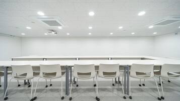 A conference room with a long table and six chairs.