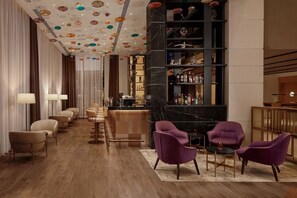 Uma área de bar moderna com balcão de mármore, assentos com luminárias e teto decorativo.