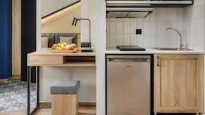 A compact kitchen with a built-in dishwasher, a small countertop, and a mirror above the sink. - Pidna Apartments (Dio-Olympos)