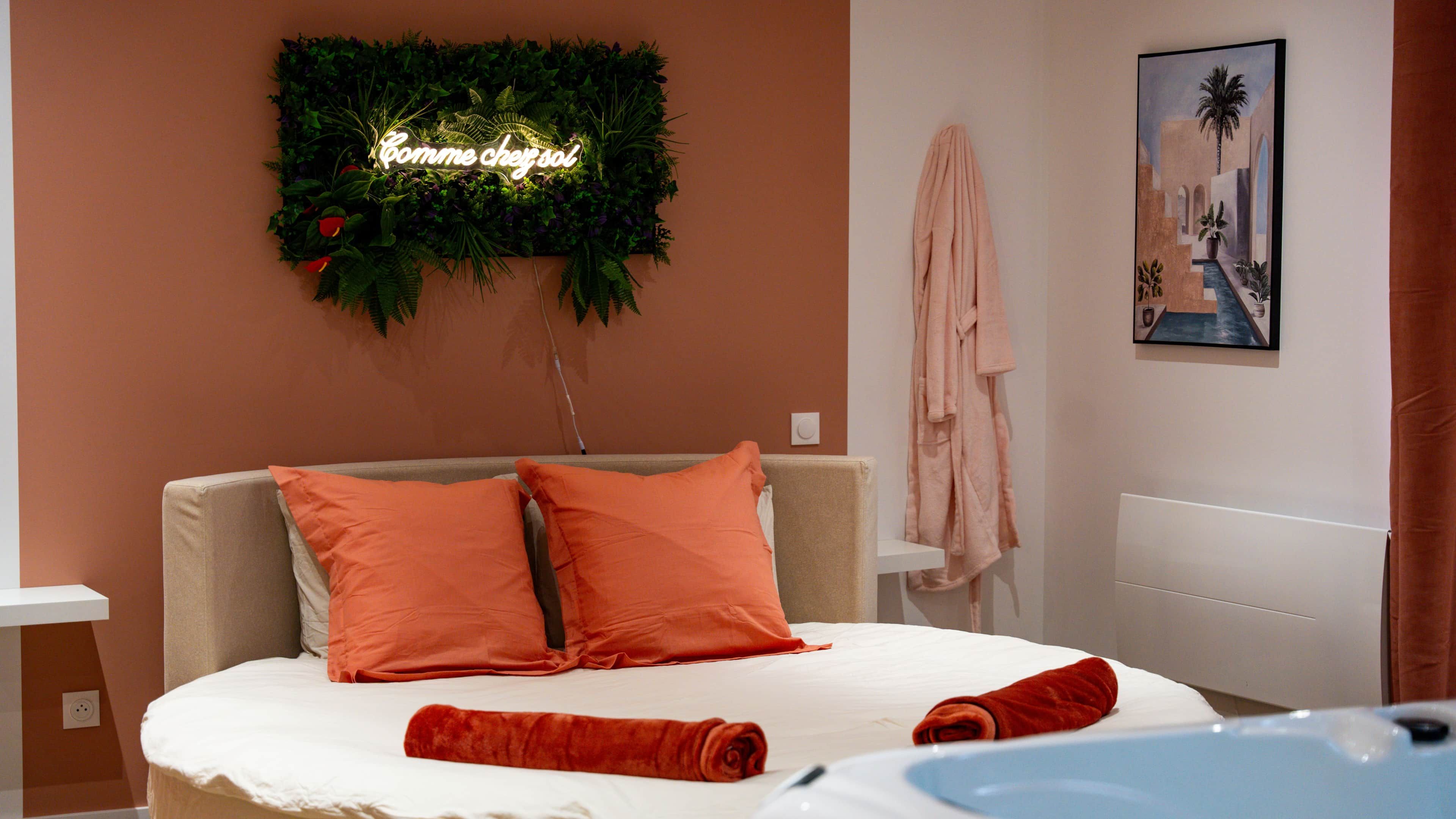 Een hotelkamer met een bed, een bord aan de muur, een schilderij en een handdoek op het bed.