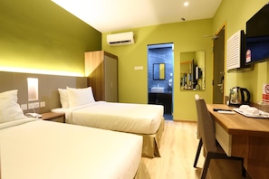 A hotel room with two beds, a desk, a chair, an air conditioning unit, a television, and a bathroom visible through an open door. - Airdence (Kota Kinabalu)