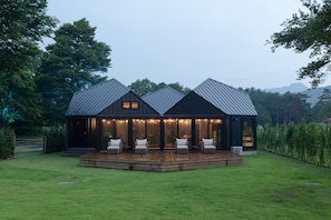 A modern house with a wooden deck and outdoor seating.