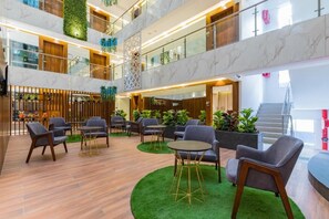 A multi-level hotel lobby with seating areas, a staircase, and a reception desk. - AR Suites Jewels Royale - Koregaon Park NX (Pune)