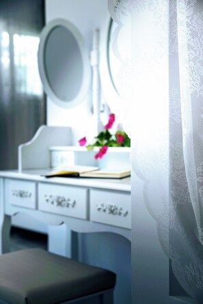 A bathroom vanity with a mirror, a sink, and a small potted plant. - Stella Maria Hotel & Suites (Hersonissos)