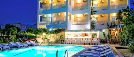 Un hôtel doté d’une piscine, d’un espace extérieur aménagé et de plusieurs balcons.