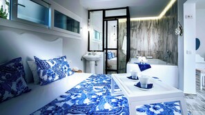 Une chambre à coucher avec un lit, une table de chevet et une vue sur la salle de bain.