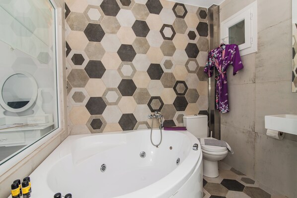 A bathroom with a large bathtub, a toilet, and a shower area. - Stella Maria Hotel & Suites (Hersonissos)