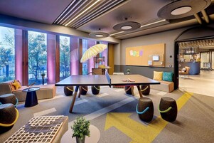 A modern meeting room with a large table, comfortable seating, and a view of the outdoors.