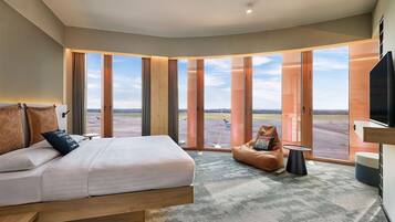 Ein modernes Hotelzimmer mit einem großen Bett, einem Sitzsack und einem Fernseher.