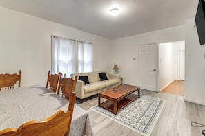A room with a bed, a sofa, a coffee table, and a dining table. - Easy Niagara Falls Access! Apt w/ Full Kitchen (Niagara Falls)